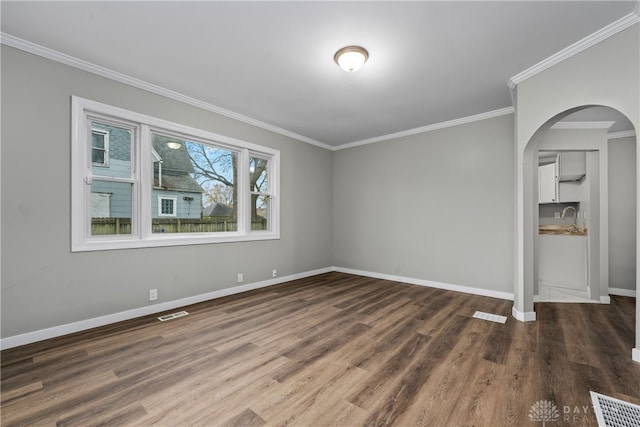 unfurnished room with crown molding, sink, and dark wood-type flooring