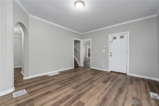 empty room featuring ornamental molding and dark wood-type flooring