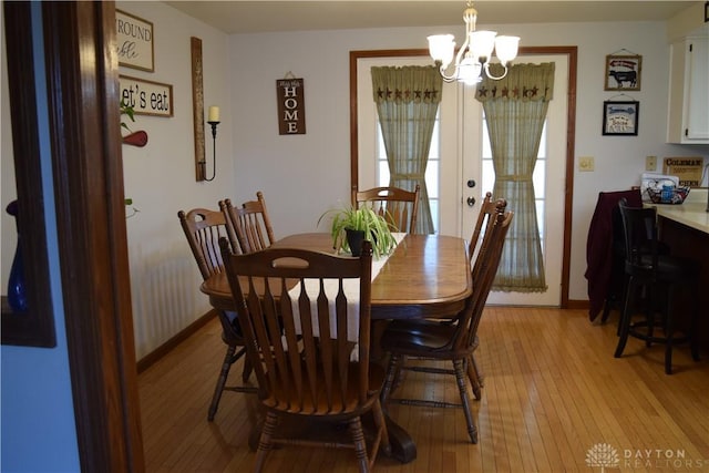 dining room featuring french doors, a notable chandelier, and light wood-type flooring