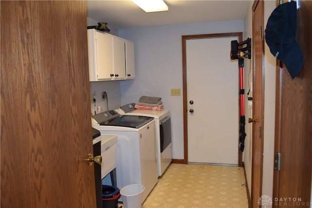 washroom with separate washer and dryer and cabinets