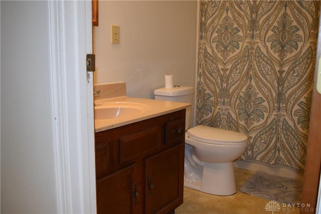 bathroom with vanity, curtained shower, and toilet