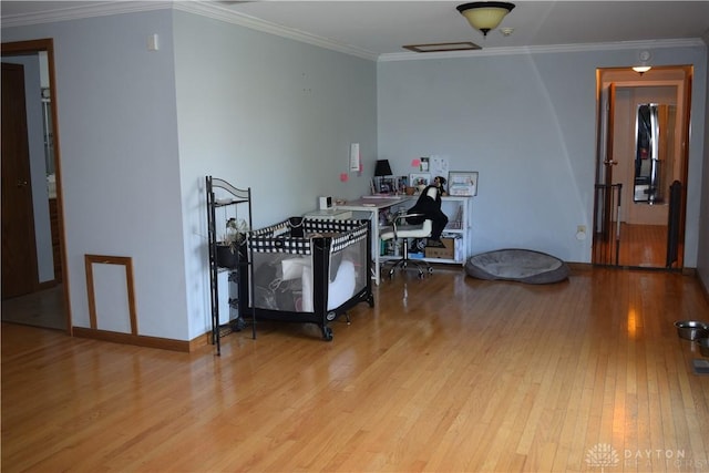 bedroom featuring crown molding and light hardwood / wood-style flooring