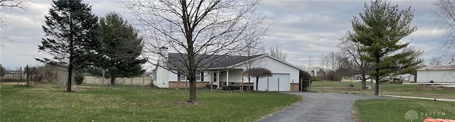 view of side of home featuring a garage and a lawn