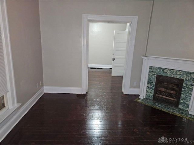 unfurnished living room with dark hardwood / wood-style flooring and a fireplace