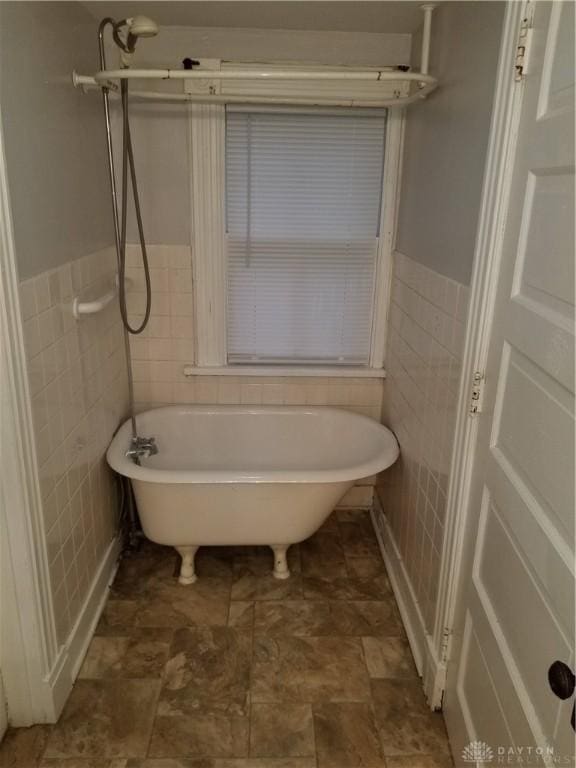 bathroom featuring tile walls and a tub