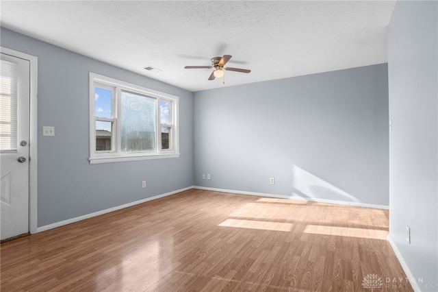 empty room featuring hardwood / wood-style floors, ceiling fan, and a textured ceiling