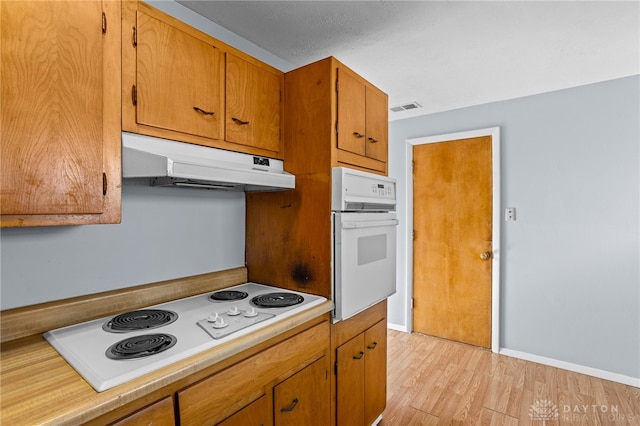 kitchen with light hardwood / wood-style floors and white appliances