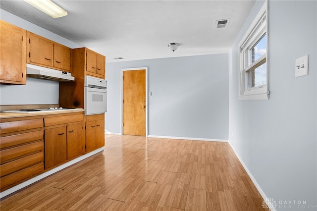 kitchen featuring white appliances and light hardwood / wood-style floors