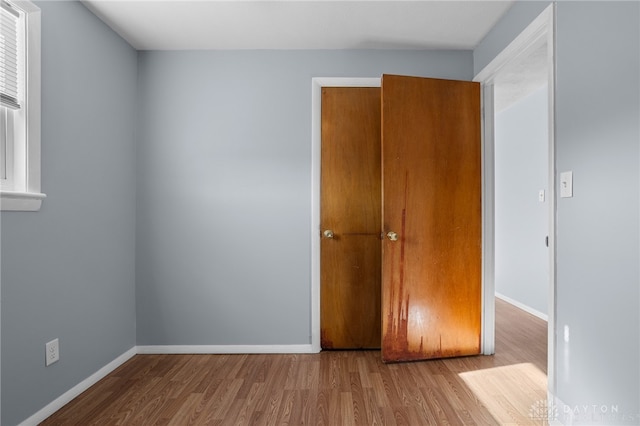 unfurnished bedroom featuring a closet and wood-type flooring