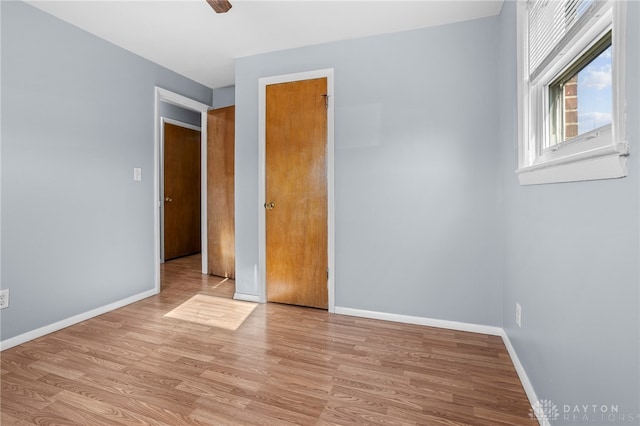 unfurnished bedroom with ceiling fan and light wood-type flooring