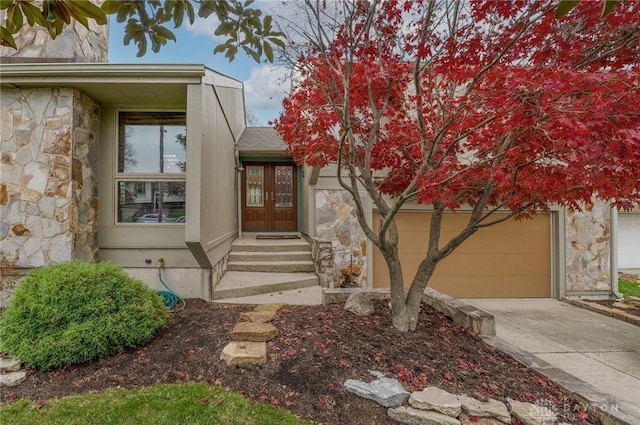 entrance to property featuring a garage and french doors