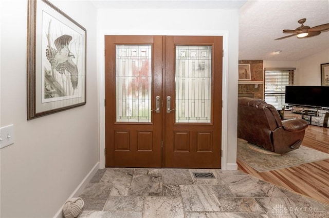 entrance foyer with ceiling fan, french doors, and a textured ceiling