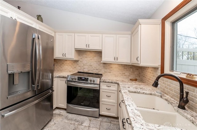 kitchen with lofted ceiling, sink, tasteful backsplash, light stone counters, and stainless steel appliances