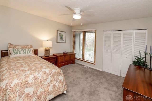 bedroom featuring light carpet, a textured ceiling, a closet, and ceiling fan