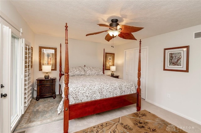 carpeted bedroom with a textured ceiling and ceiling fan