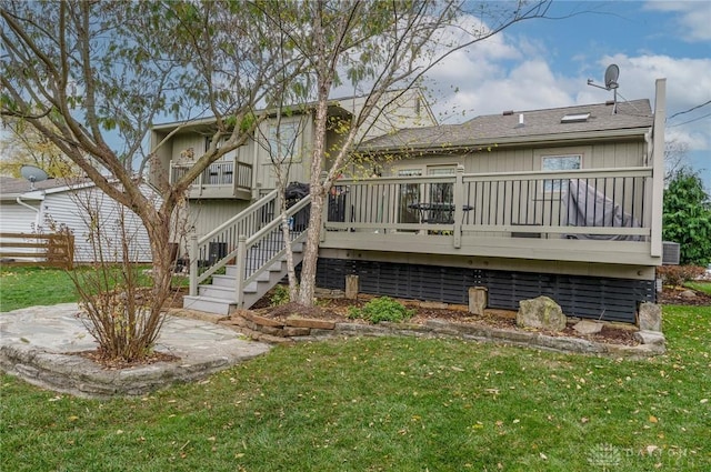 rear view of property featuring a lawn and a wooden deck