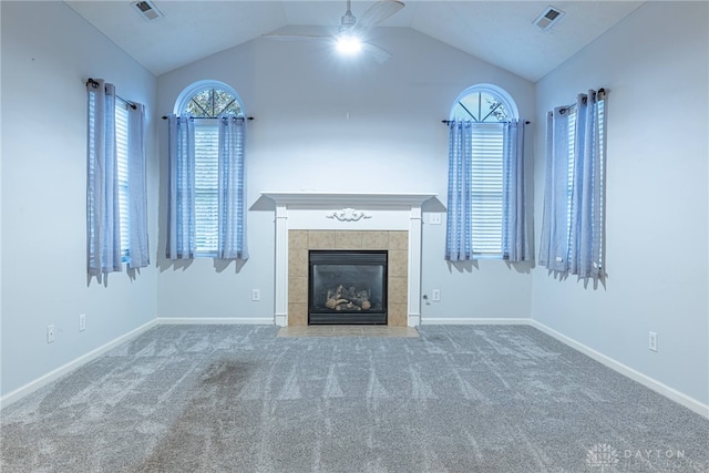 unfurnished living room with carpet, ceiling fan, lofted ceiling, and a tiled fireplace