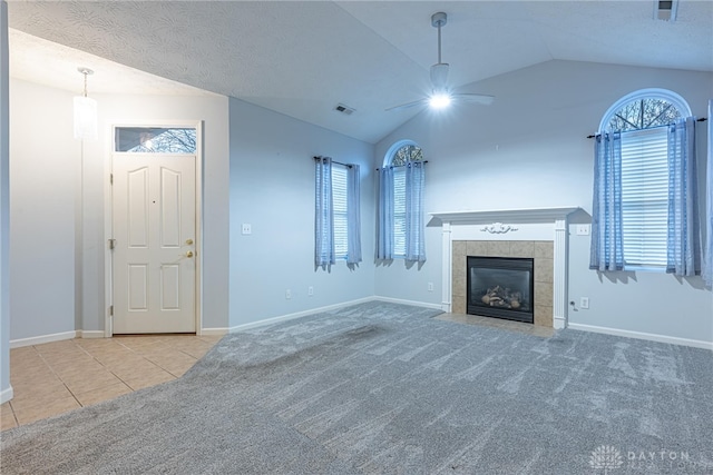 unfurnished living room featuring a fireplace, light colored carpet, plenty of natural light, and lofted ceiling