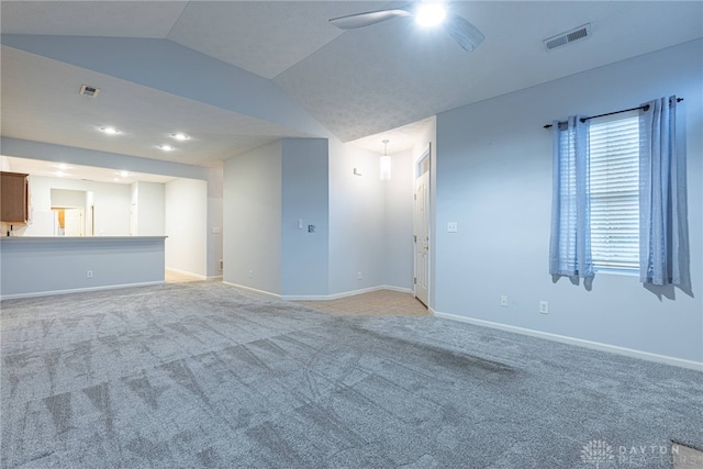 unfurnished living room featuring ceiling fan, light carpet, and vaulted ceiling