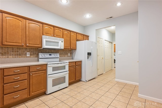 kitchen featuring light tile patterned floors, white appliances, a textured ceiling, and backsplash