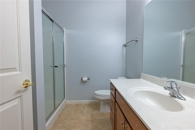 bathroom with a shower with door, vanity, and toilet