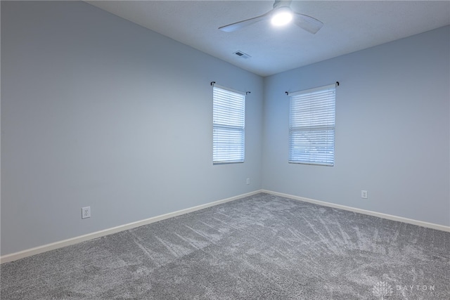 carpeted spare room featuring ceiling fan