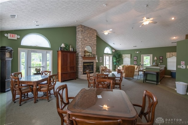 carpeted dining room with a fireplace, a healthy amount of sunlight, a textured ceiling, and ceiling fan