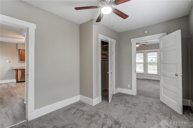 unfurnished bedroom featuring ceiling fan, a closet, and light carpet