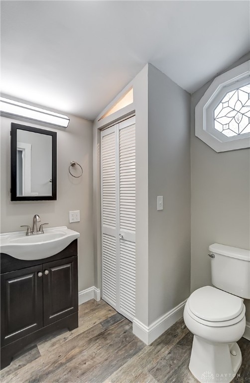 bathroom featuring toilet, vanity, and hardwood / wood-style flooring