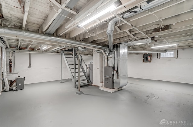 basement featuring electric panel and heating unit