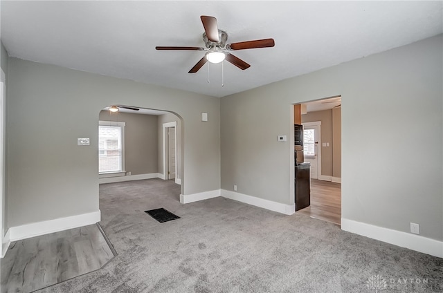 carpeted spare room featuring ceiling fan