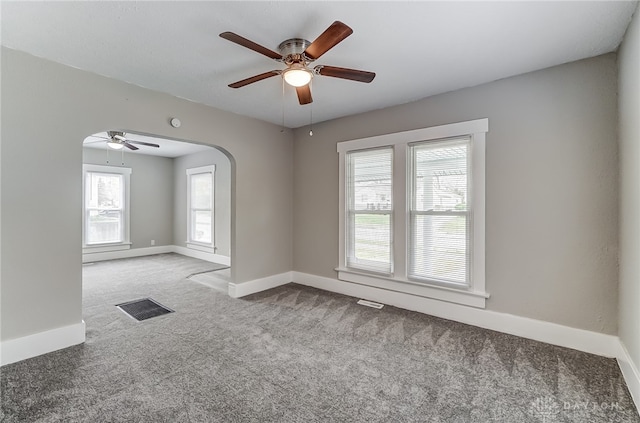 carpeted spare room featuring ceiling fan