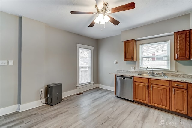 kitchen with stainless steel dishwasher, ceiling fan, light hardwood / wood-style floors, and sink