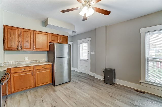 kitchen featuring ceiling fan, light wood-type flooring, and stainless steel appliances