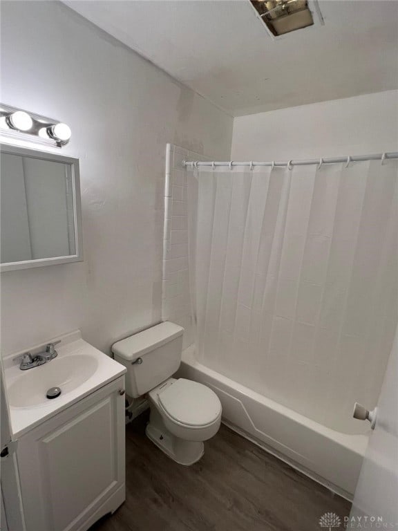 full bathroom featuring hardwood / wood-style flooring, vanity, toilet, and shower / tub combo