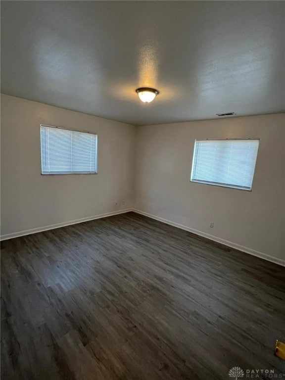 spare room with dark hardwood / wood-style floors