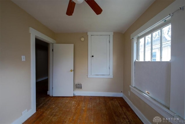 unfurnished bedroom with ceiling fan and dark wood-type flooring