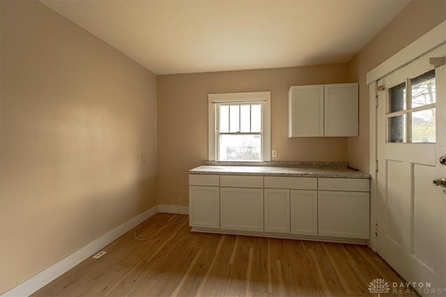 kitchen with light hardwood / wood-style floors and white cabinetry