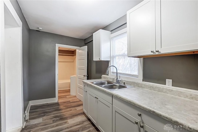 kitchen with white cabinetry, dark wood-type flooring, and sink