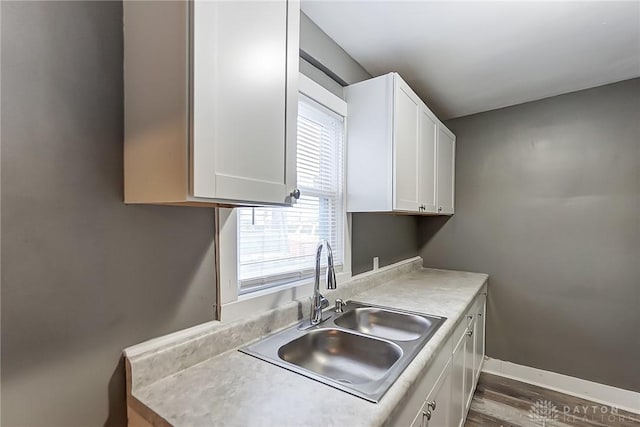 kitchen featuring white cabinets, sink, and hardwood / wood-style flooring