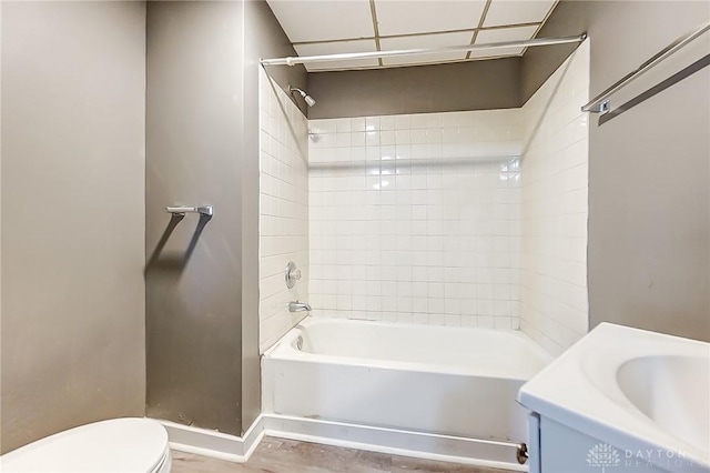 full bathroom featuring vanity, tiled shower / bath combo, and toilet