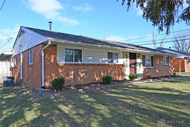 ranch-style house with cooling unit and a front lawn