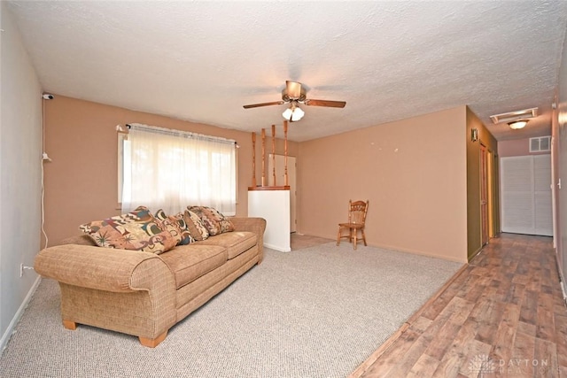 living room with hardwood / wood-style floors, a textured ceiling, and ceiling fan