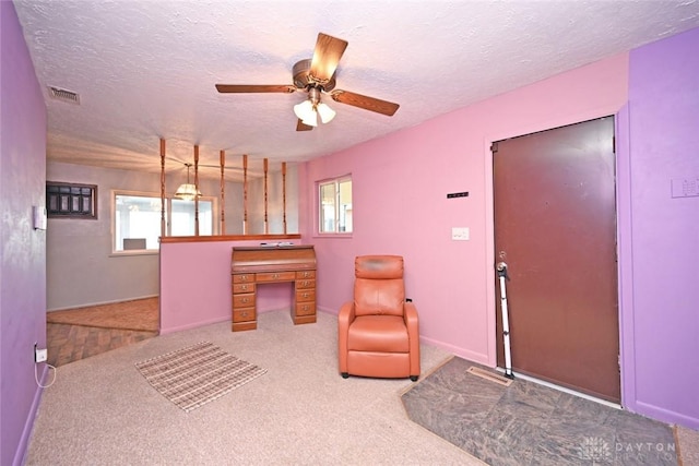 interior space featuring a textured ceiling, carpet floors, and ceiling fan