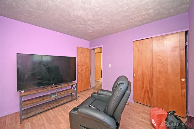 living room with light wood-type flooring and a textured ceiling