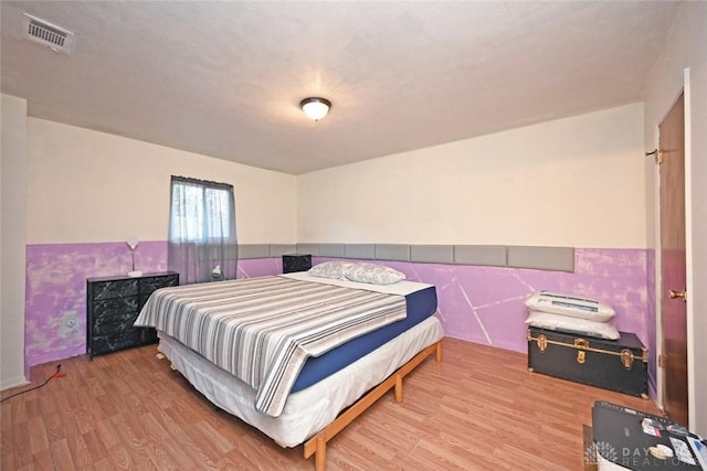 bedroom featuring a textured ceiling and light hardwood / wood-style floors