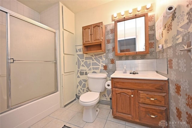 full bathroom featuring shower / bath combination with glass door, tile patterned floors, vanity, and toilet