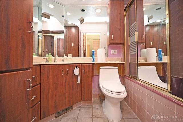 full bathroom with tile patterned floors, vanity, toilet, and enclosed tub / shower combo