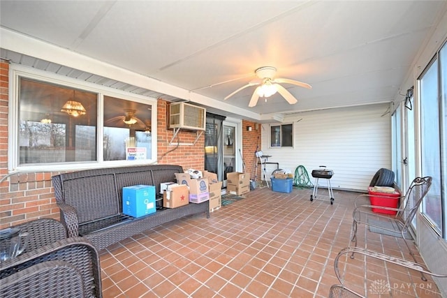 sunroom / solarium with a wall mounted air conditioner and ceiling fan