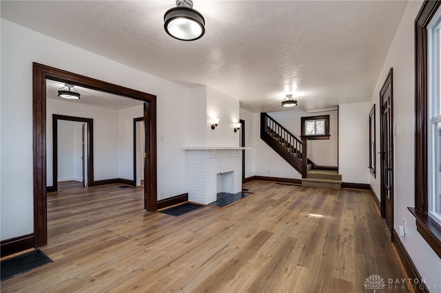 unfurnished living room with a fireplace and wood-type flooring